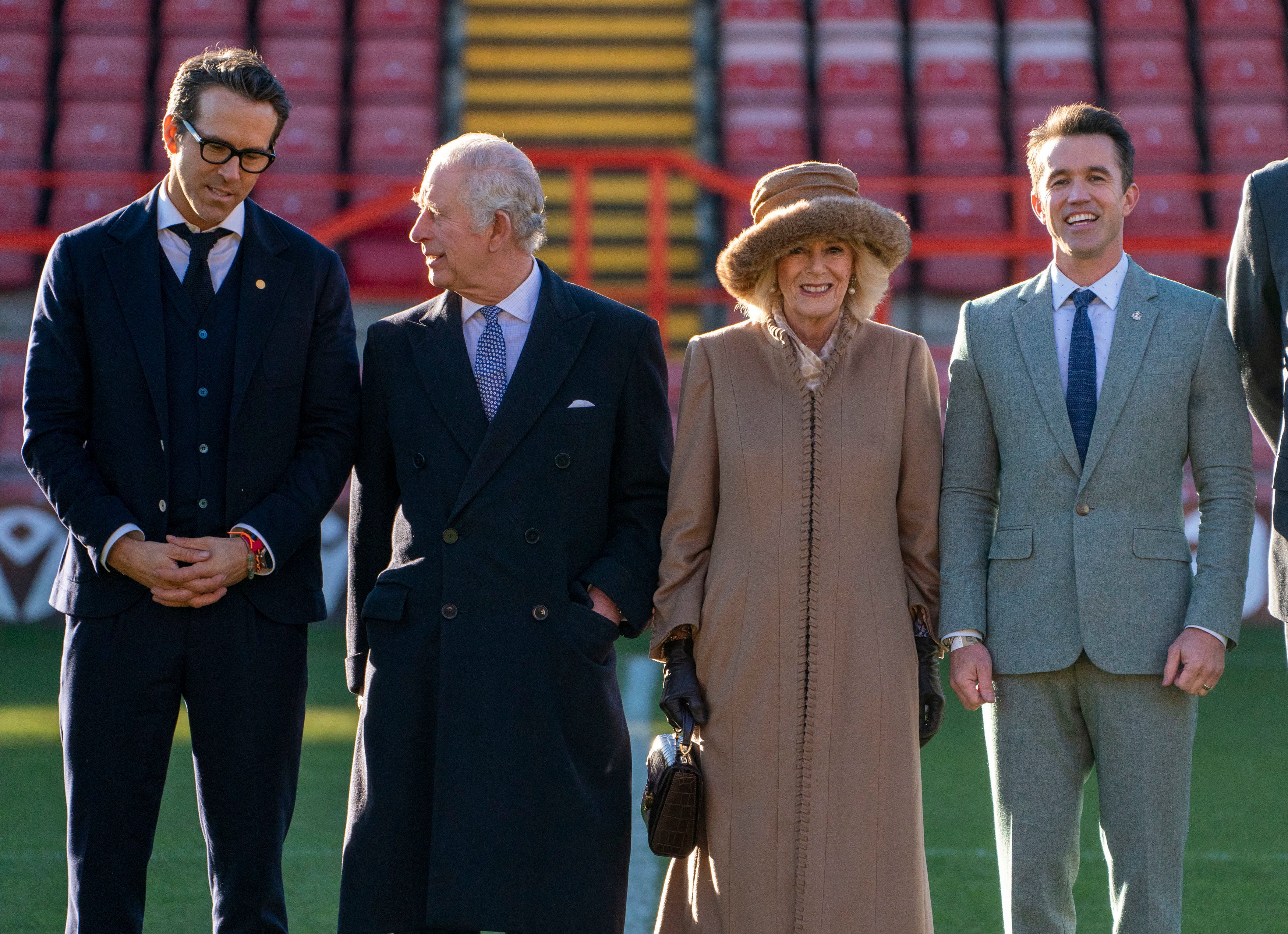 Le roi Charles III, à gauche, et Camilla, la reine consort, discutent avec les co-propriétaires du club de football de Wrexham, Ryan Reynolds et Rob McElhenney, lors de leur visite au stade de Wrexham.