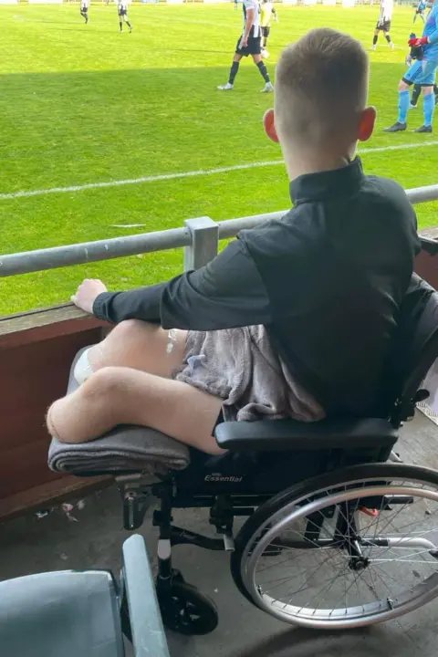 Adam Golebiewski regarde son équipe jouer depuis son fauteuil roulant.