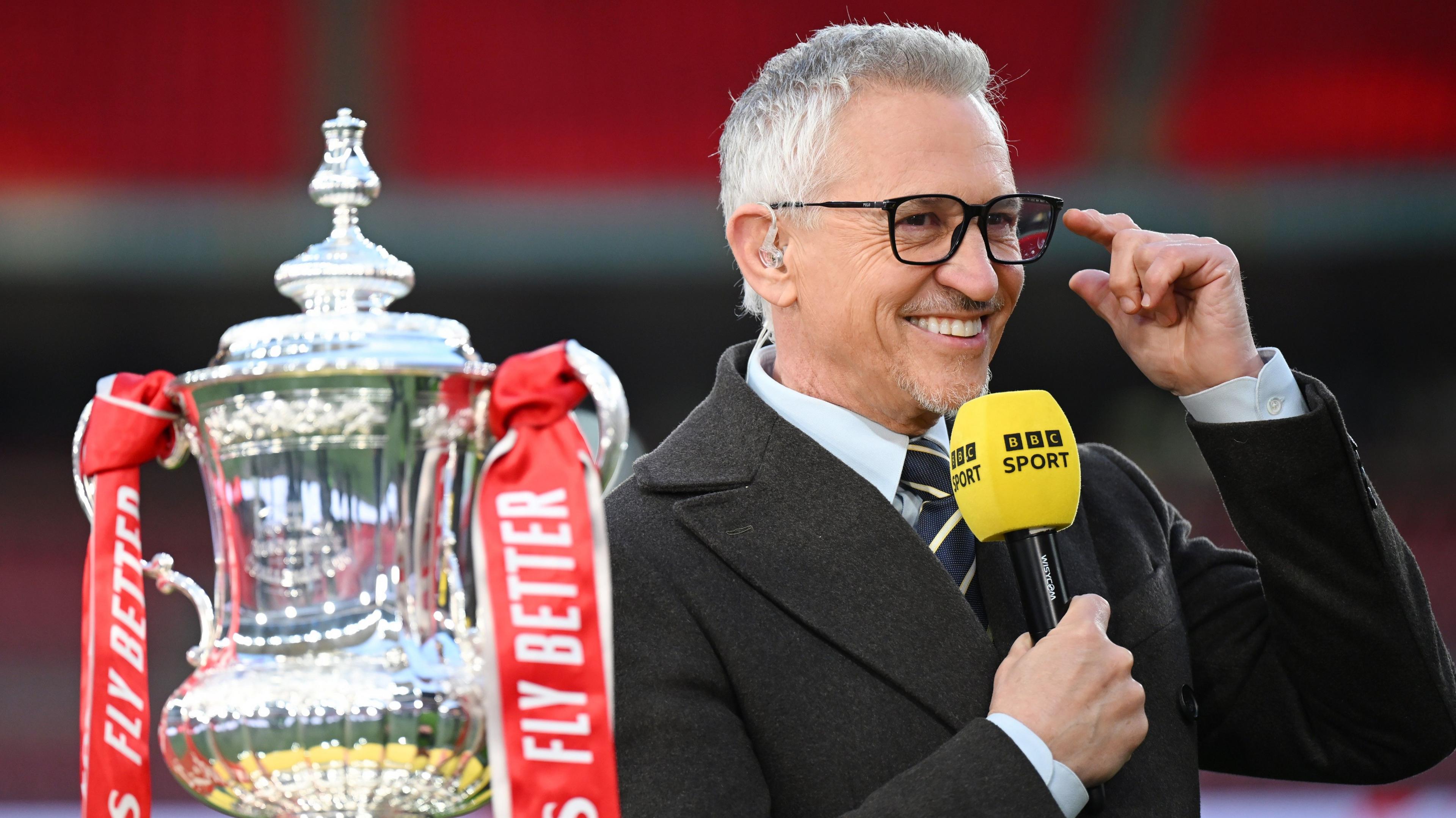 Gary Lineker sourit en tenant un microphone de BBC Sport