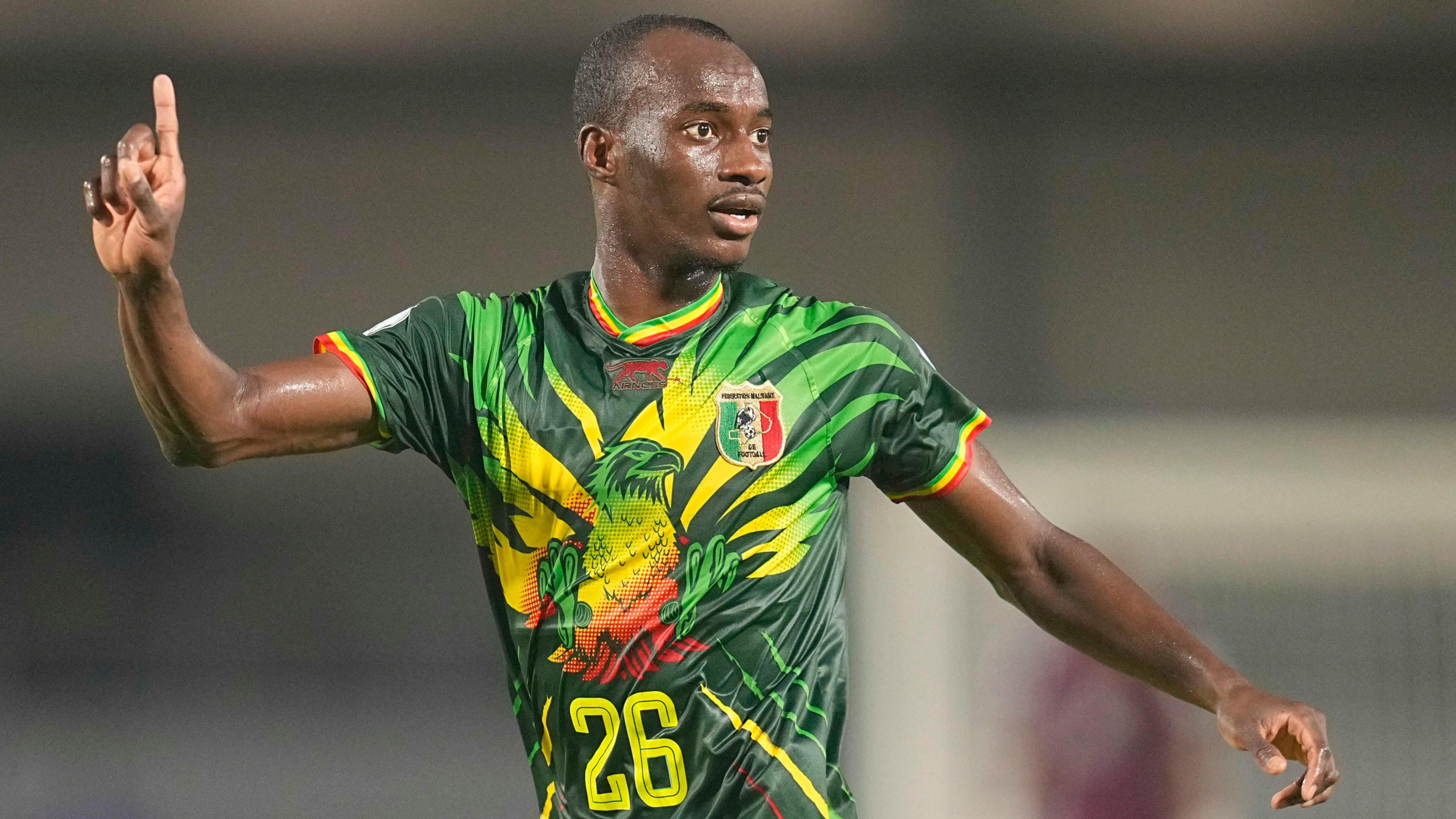 Kamory Doumbia, porte un maillot vert du Mali, en train de célébrer après avoir marqué