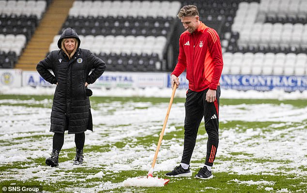 Aberdeen defender Angus MacDonald helps clear the St Mirren pitch before their match