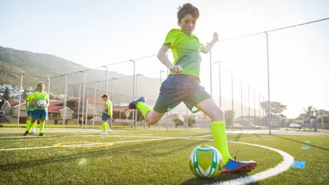 Un jeune garçon s'apprête à frapper un ballon sur le terrain.