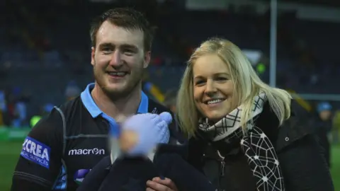 Stuart Hogg avec sa femme et un enfant sur le terrain de rugby