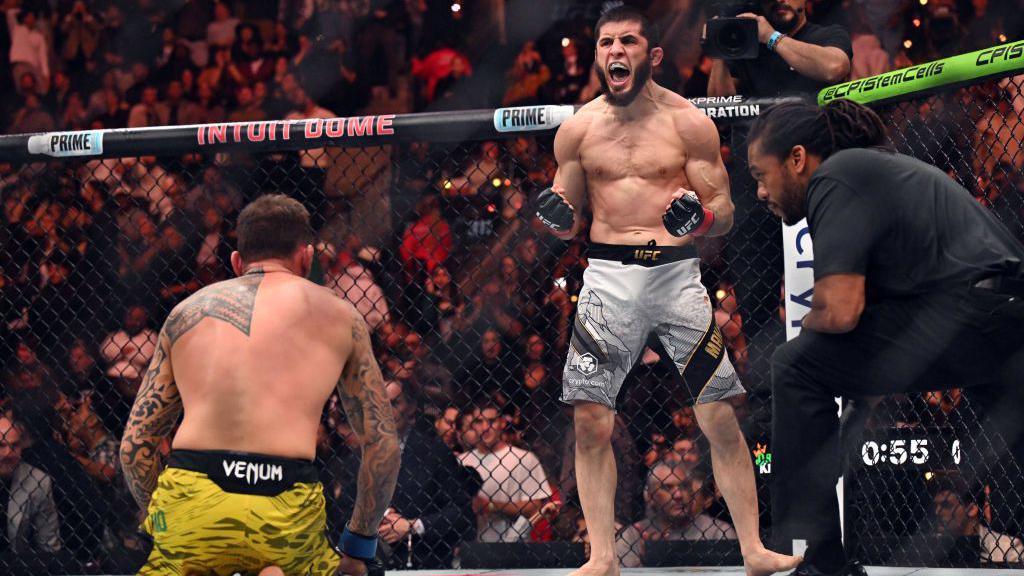 Islam Makhachev célèbre sa victoire avec Renato Moicano à genoux dans l'octogone