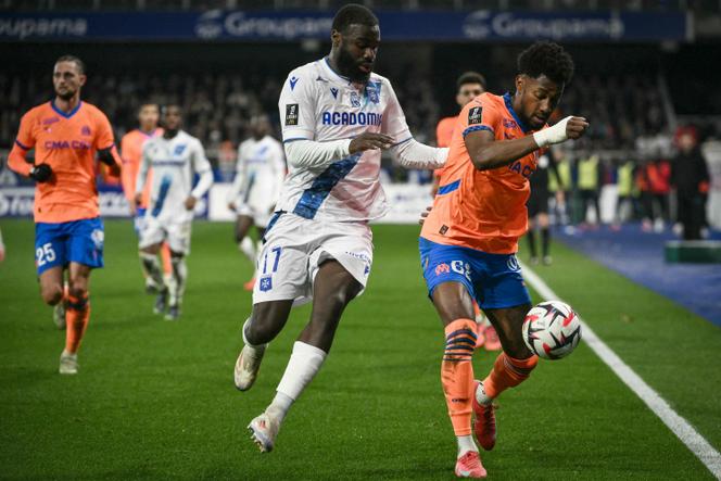 Le Marseillais Amir Murillo (à droite) et l’Auxerrois Lassine Sinayoko (au centre) lors de leur match au stade de l’Abbé-Descamps, à Auxerre, le 22 février 2025.