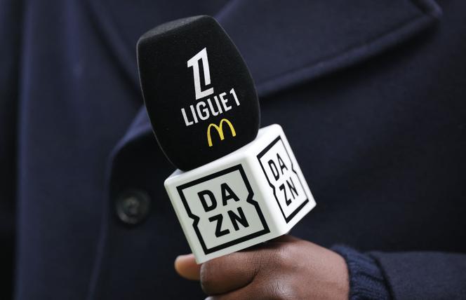 Un speaker tient un micro avec le logo du diffuseur TV DAZN avant le match de Ligue 1 entre le FC Nantes et le RC Lens, au stade de la Beaujoire, le 23 février 2025.